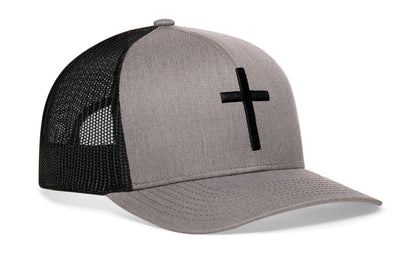 gray-black trucker hat viewed from the right side, showcasing a bold cross bold white 3D embroidery prominently displayed on the front