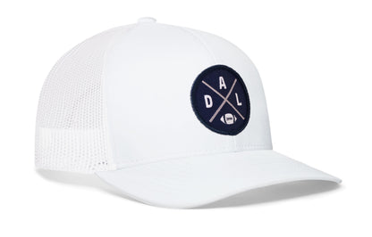 white trucker hat viewed from the right side, showcasing a bold navy blue and silver embroidered X patch prominently displayed on the front