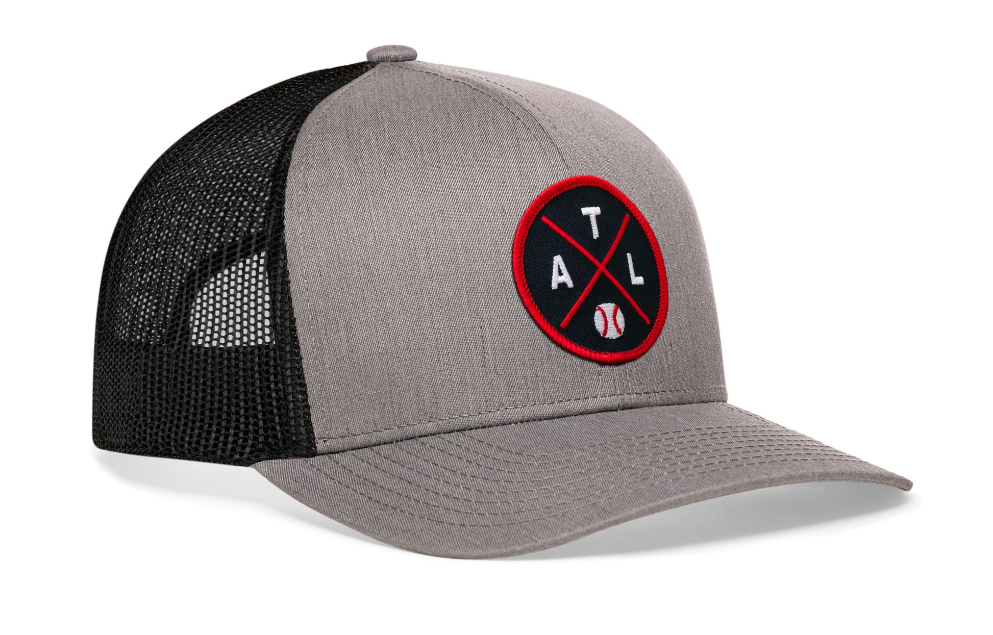 gray-black trucker hat viewed from the right side, showcasing a bold navy and red embroidered X patch prominently displayed on the front