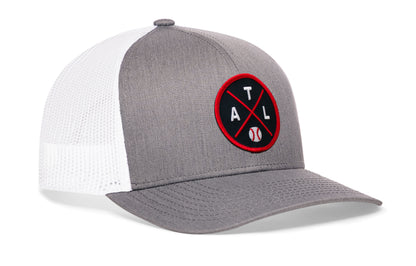 gray-white trucker hat viewed from the right side, showcasing a bold navy and red embroidered X patch prominently displayed on the front