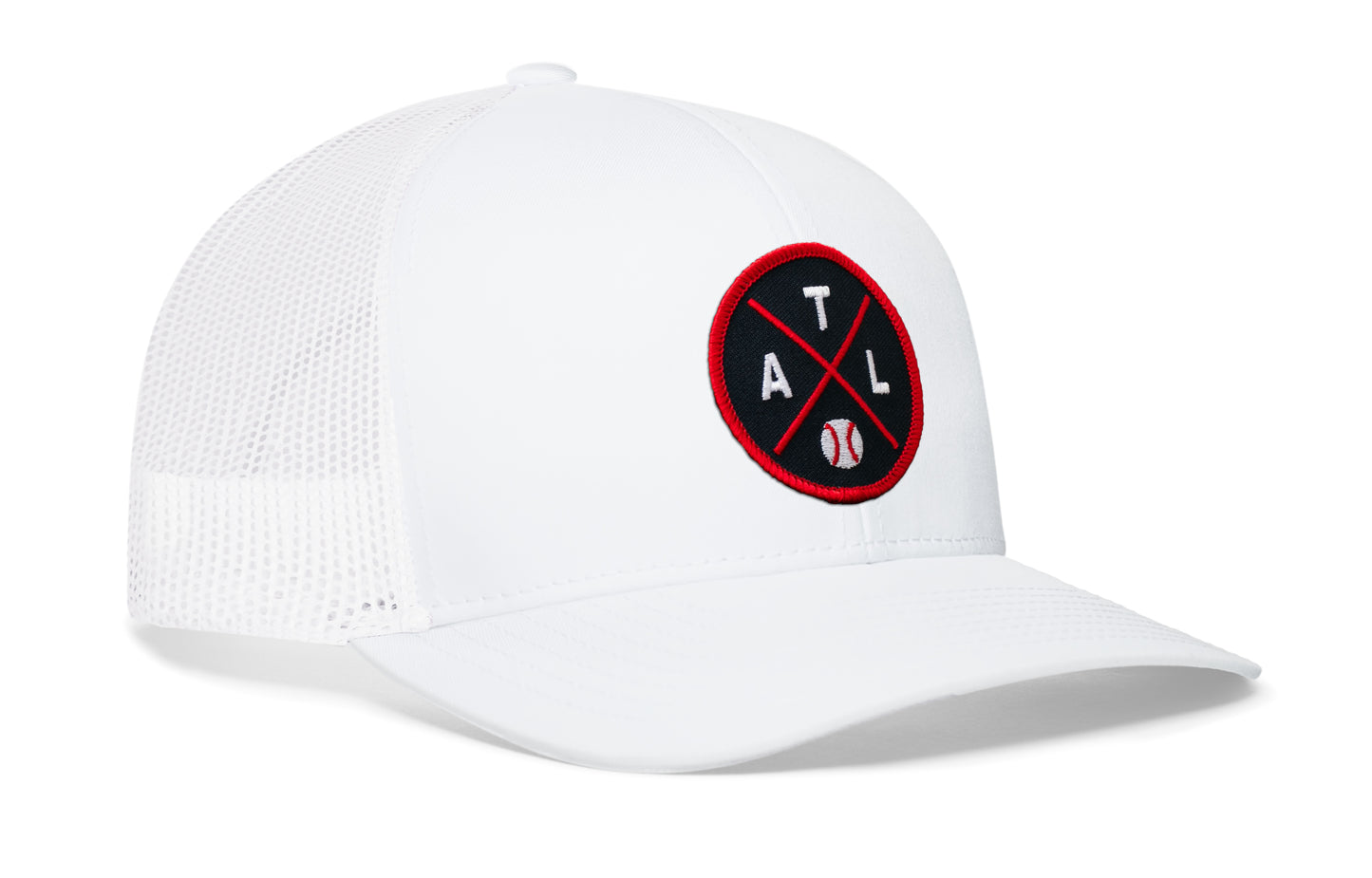 white trucker hat viewed from the right side, showcasing a navy and red baseball embroidered X patch prominently displayed on the front