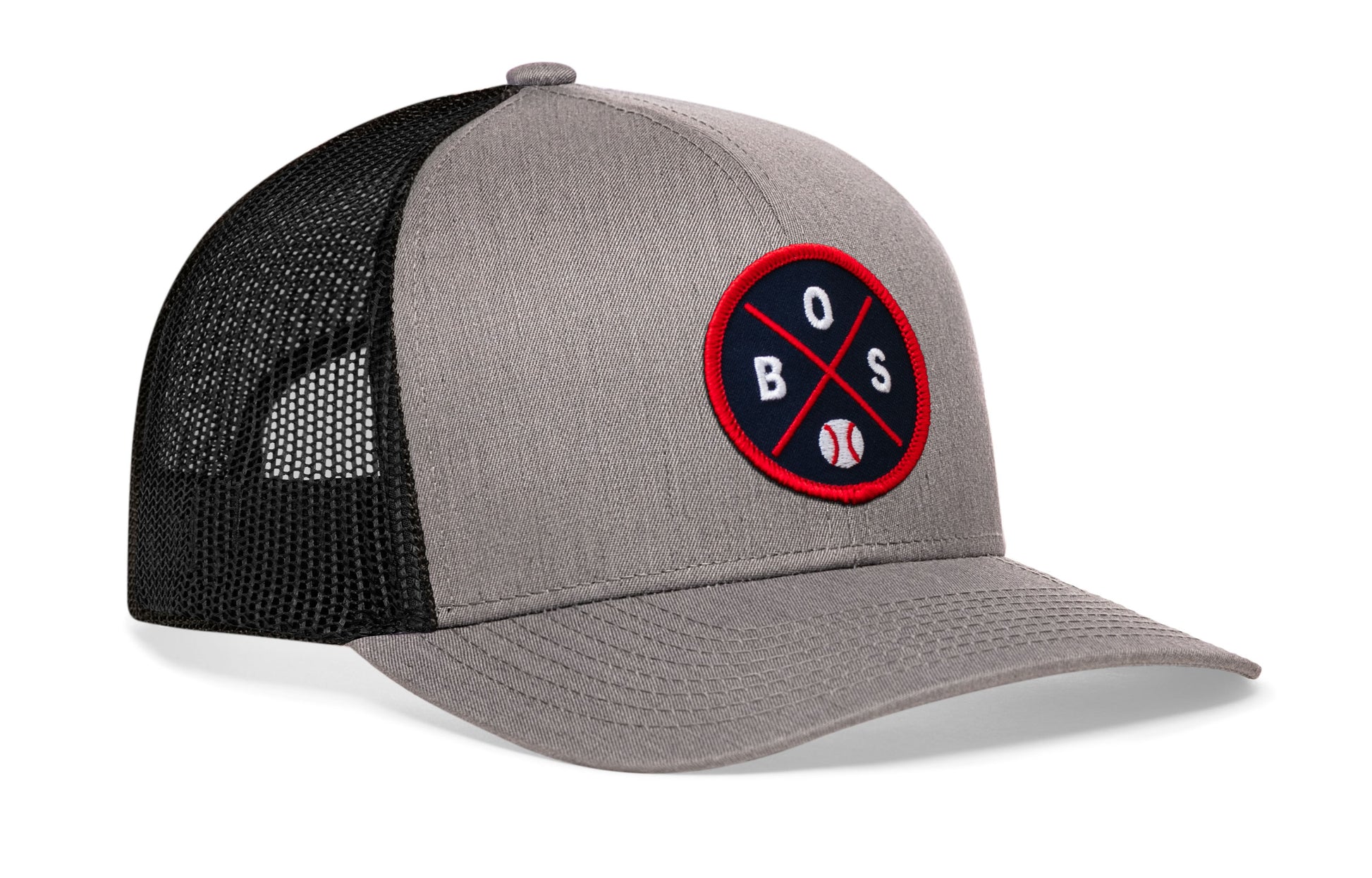 gray-black trucker hat viewed from the right side, showcasing a bold navy and red embroidered X patch prominently displayed on the front