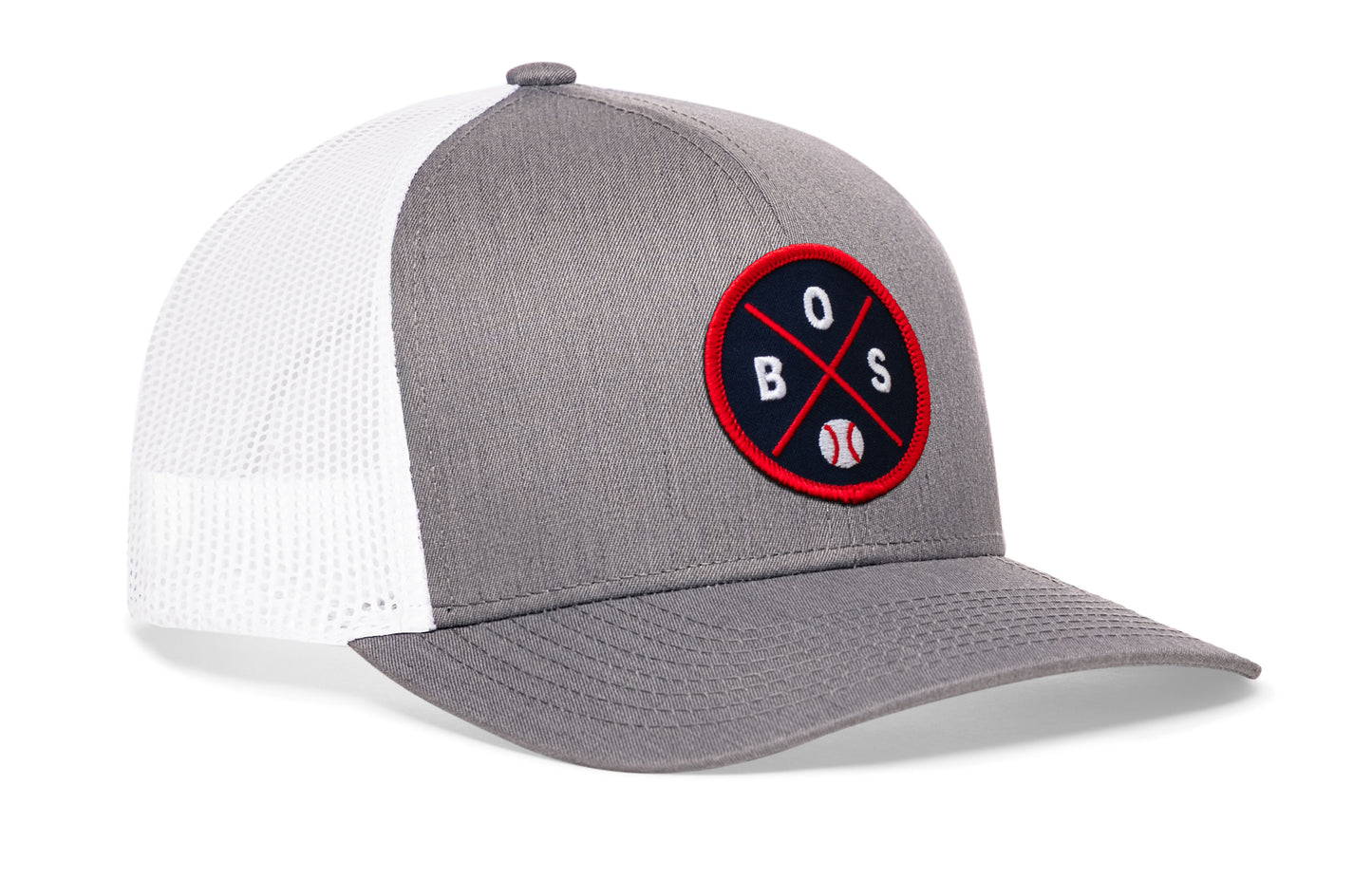 gray-white trucker hat viewed from the right side, showcasing a bold navy and red embroidered X patch prominently displayed on the front