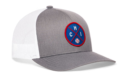gray-white trucker hat viewed from the right side, showcasing a bold royal and red embroidered X patch prominently displayed on the front