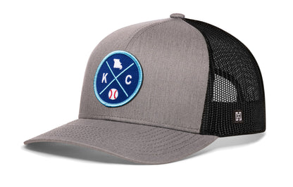 Kansas City trucker hat, gray-black snapback showing Haka brandmark on left side mesh.
Rep Kansas City, MO.
