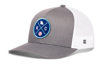 Kansas City trucker hat, gray-white snapback showing Haka brandmark on left side mesh.
Rep Kansas City, MO.
