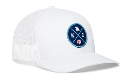 white trucker hat viewed from the right side, showcasing a royal and columbia blue baseball embroidered X patch prominently displayed on the front