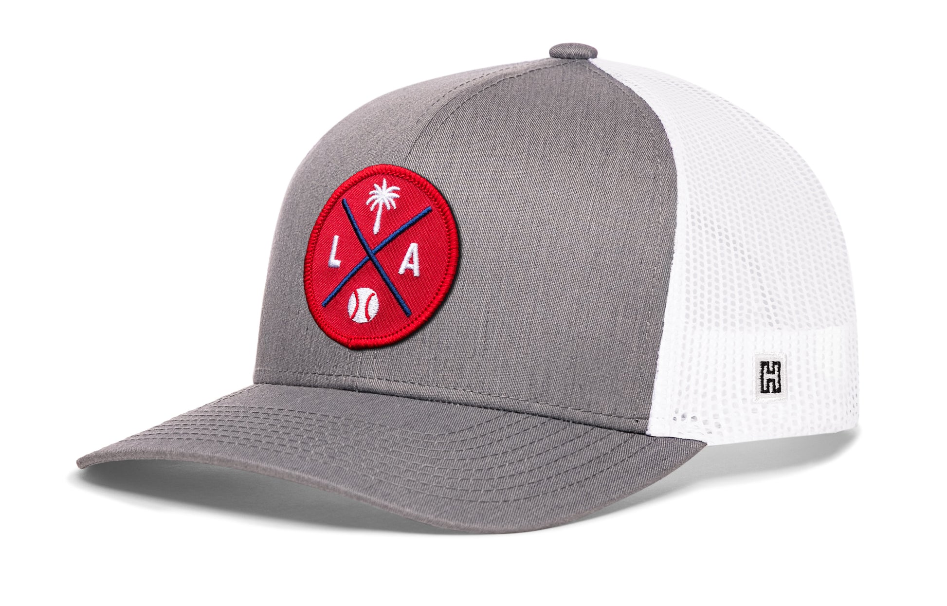 Los Angeles trucker hat, gray-white snapback showing Haka brandmark on left side mesh.
Rep Los Angeles, CA.