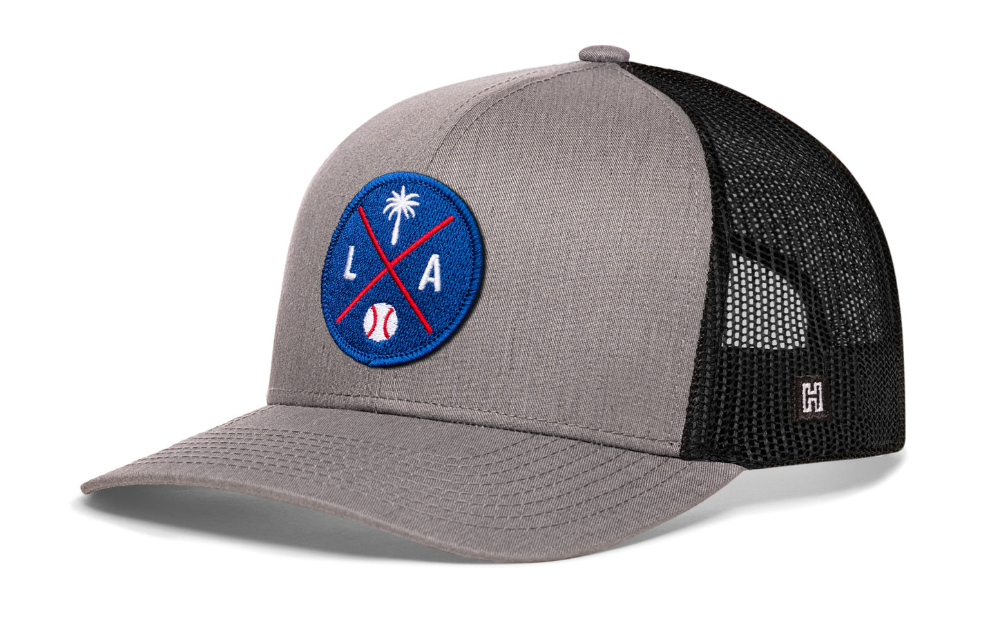 Los Angeles trucker hat, gray-black snapback showing Haka brandmark on left side mesh.
Rep Los Angeles, CA.