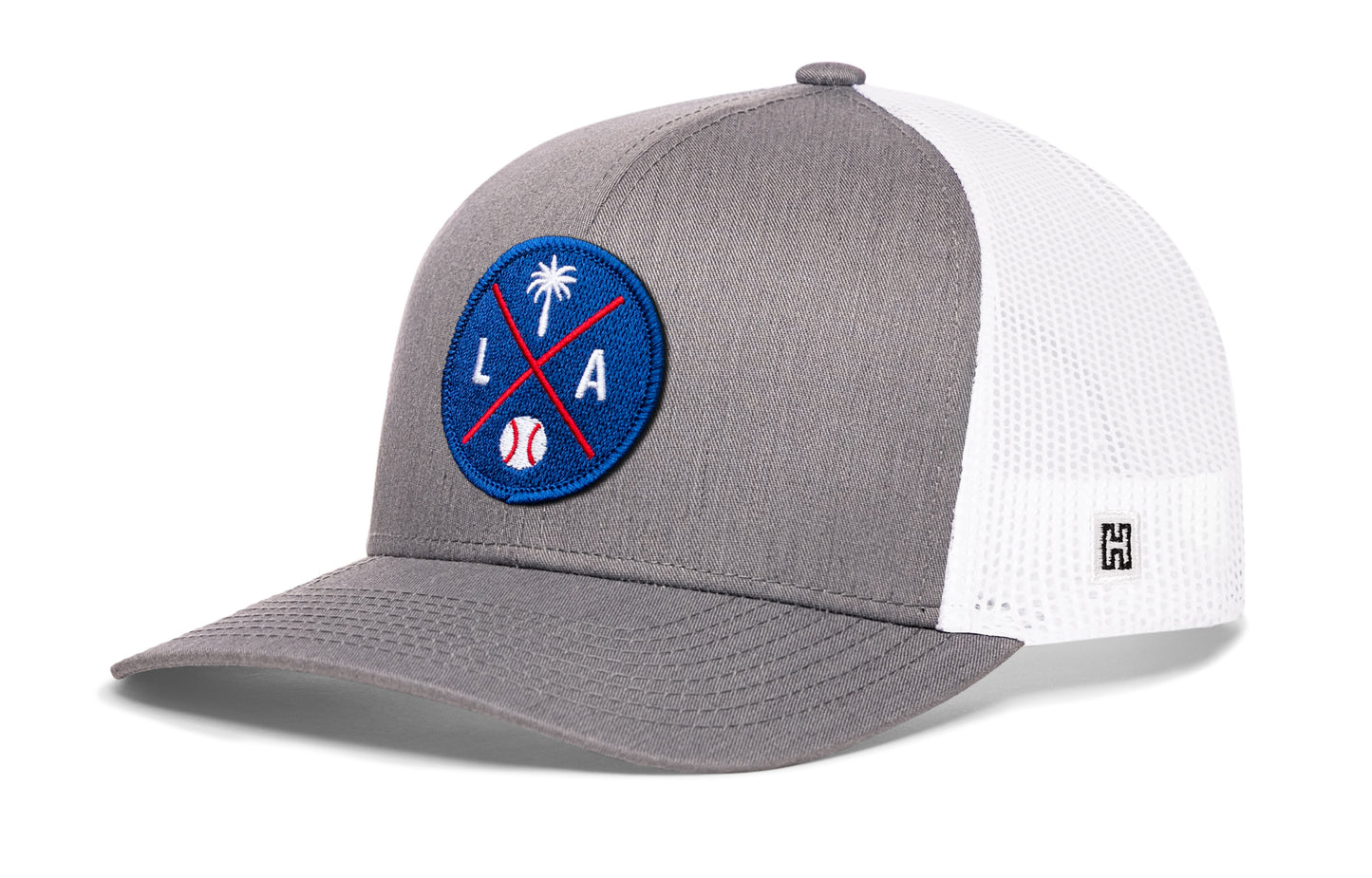 Los Angeles trucker hat, gray-white snapback showing Haka brandmark on left side mesh.
Rep Los Angeles, CA.