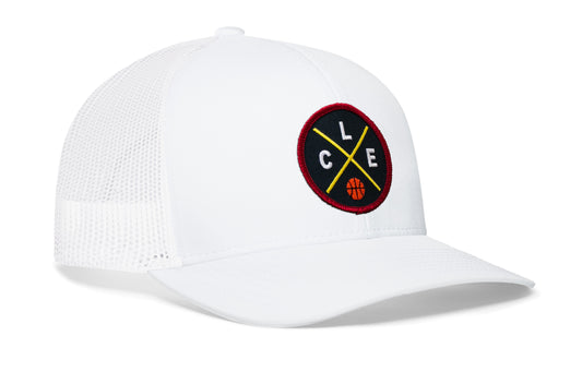 white trucker hat viewed from the right side, showcasing a navy, red and gold basketball embroidered X patch prominently displayed on the front