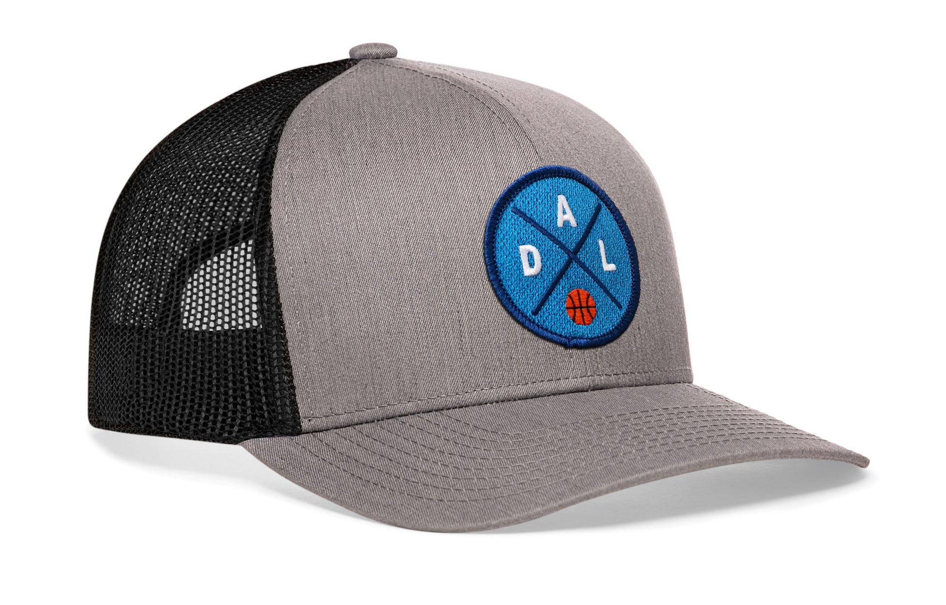 gray-black trucker hat viewed from the right side, showcasing a bold navy and royal embroidered X patch prominently displayed on the front