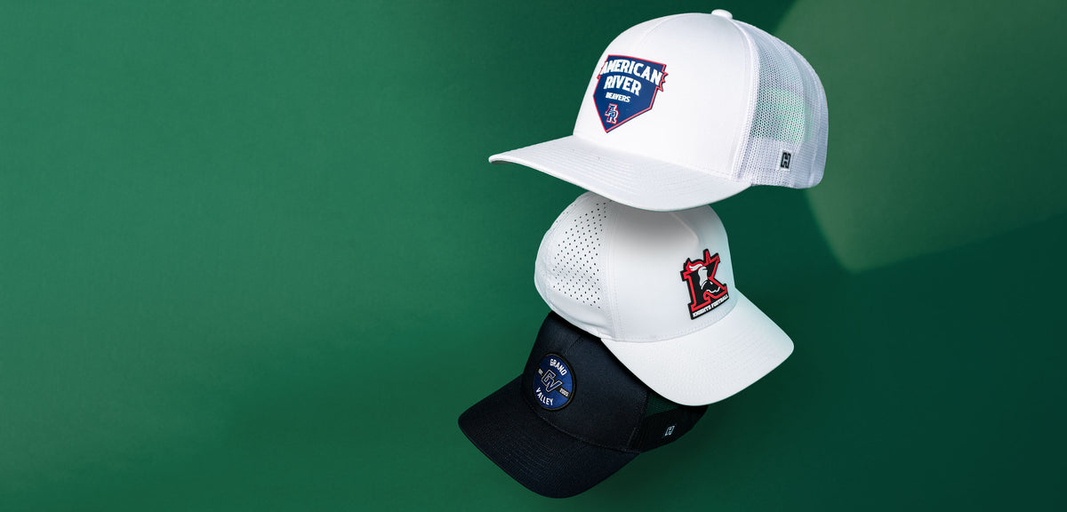 Three custom Haka hats cascading in both performance and trucker hats showcasing custom brand logos on a green background