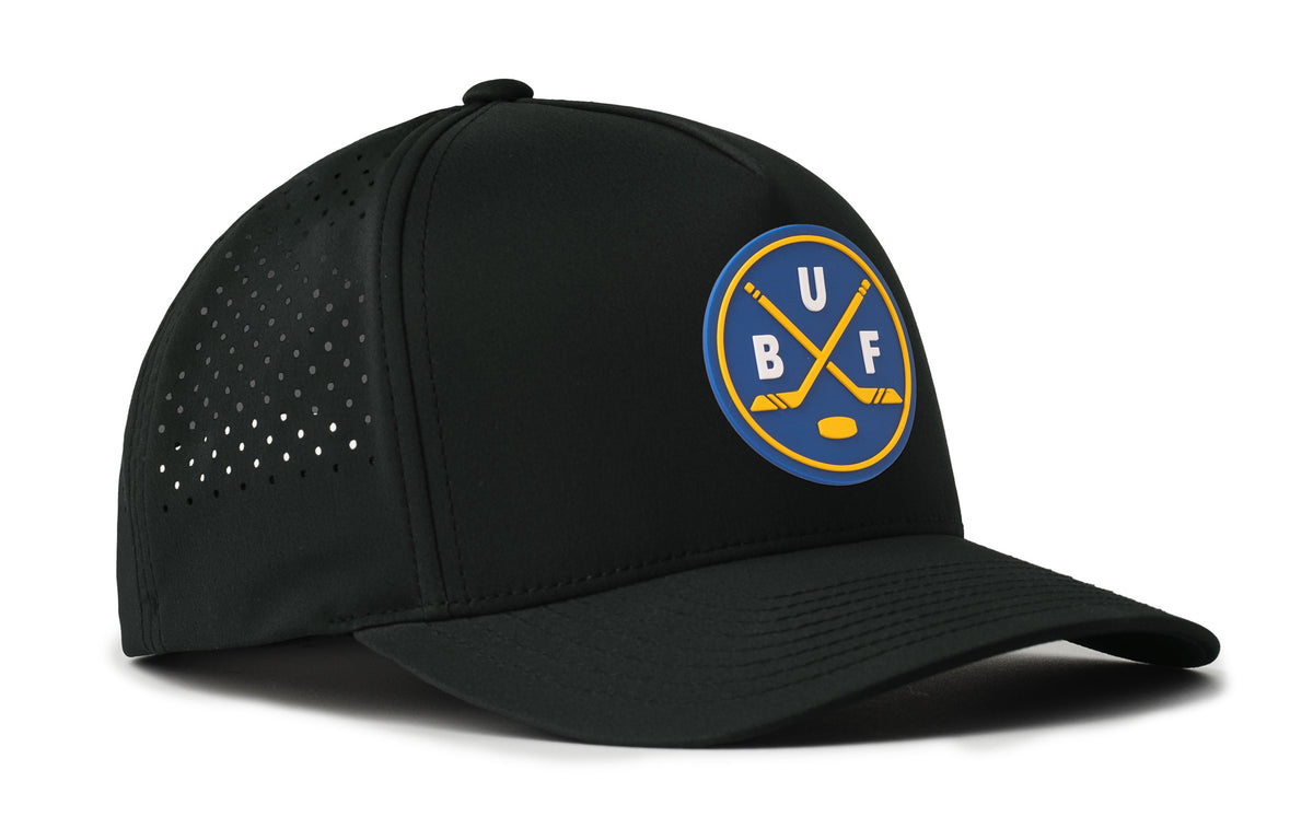 black performance 5-panel hat viewed from the right side, showcasing a bold royal and gold pvc patch prominently displayed on the front