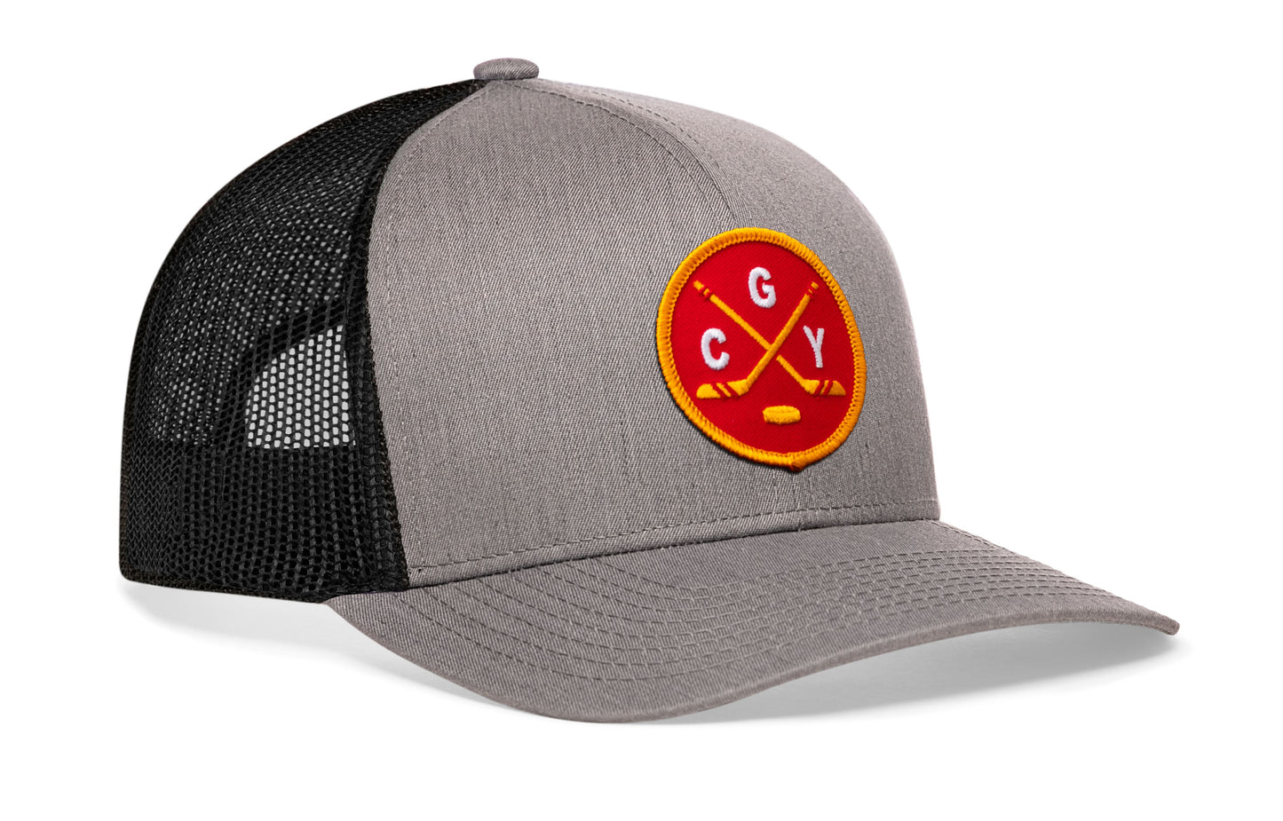 gray-black trucker hat viewed from the right side, showcasing a bold red and gold embroidered X patch prominently displayed on the front