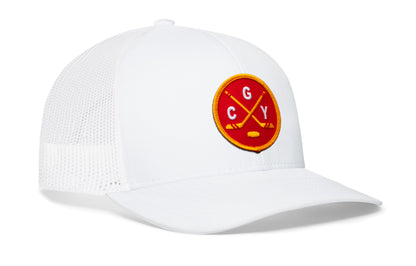 white trucker hat viewed from the right side, showcasing a red and gold hockey embroidered X patch prominently displayed on the front