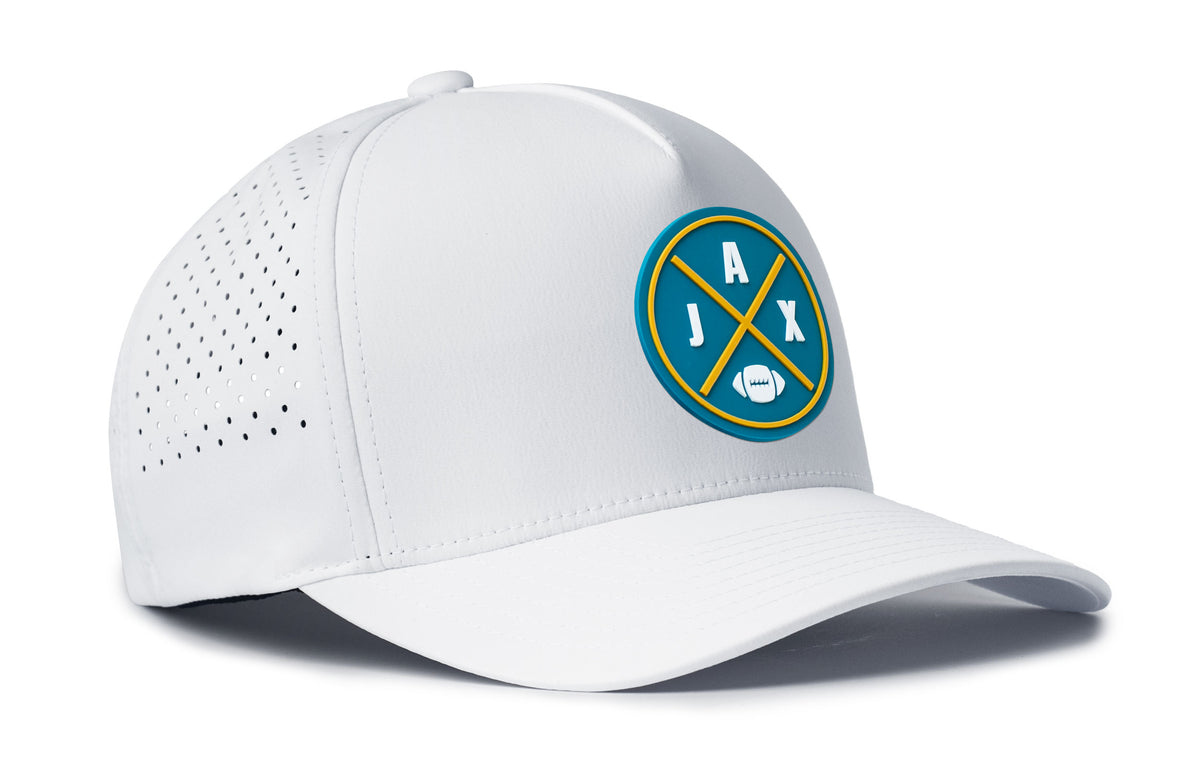 white performance 5-panel hat viewed from the right side, showcasing a bold teal and gold pvc patch prominently displayed on the front