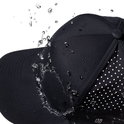 Navy performance hat with water droplets splashing onto it against a white background