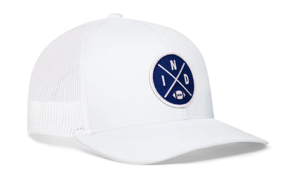 white trucker hat viewed from the right side, showcasing a bold blue and white embroidered X patch prominently displayed on the front