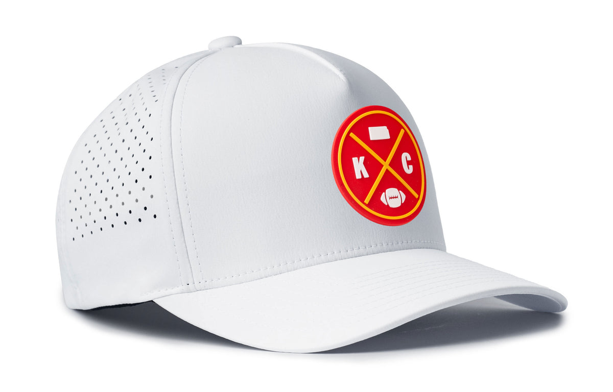 white performance 5-panel hat viewed from the right side, showcasing a bold red and gold pvc patch prominently displayed on the front