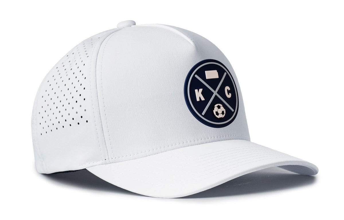 white performance 5-panel hat viewed from the right side, showcasing a bold sky blue and navy pvc patch prominently displayed on the front