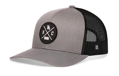 Kansas City Trucker Hat, gray-black snapback showing Haka brandmark on left side of cap.