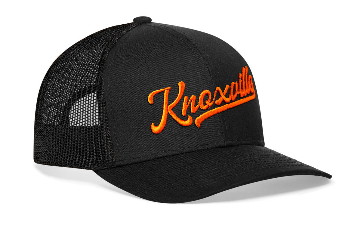 black trucker hat viewed from the right side, showcasing a bold orange 3D embroidery prominently displayed on the front