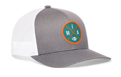 gray-white trucker hat viewed from the right side, showcasing a bold aqua and orange embroidered X patch prominently displayed on the front