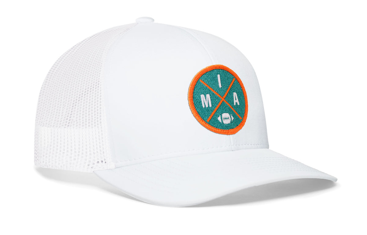 white trucker hat viewed from the right side, showcasing a bold aqua and orange embroidered X patch prominently displayed on the front