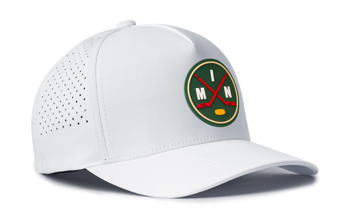 white performance 5-panel hat viewed from the right side, showcasing a bold green, red and gold pvc patch prominently displayed on the front