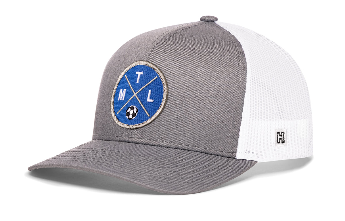 Montreal Soccer Trucker Hat, gray-white snapback showing Haka brandmark on left side of cap.