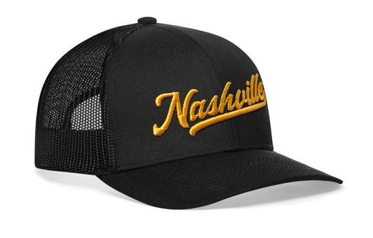 black trucker hat viewed from the right side, showcasing a Gold Nashville Script 3D embroidery prominently displayed on the front