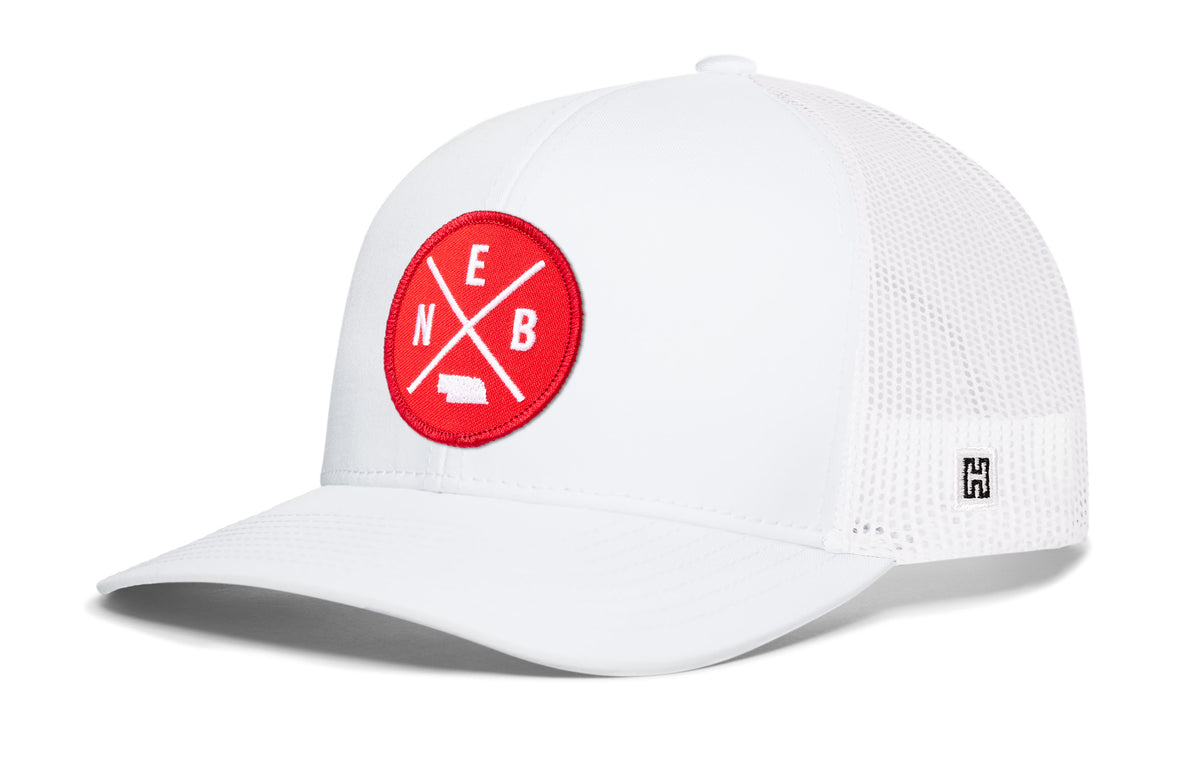 Nebraska Trucker Hat, white snapback showing Haka brandmark on left side of cap.