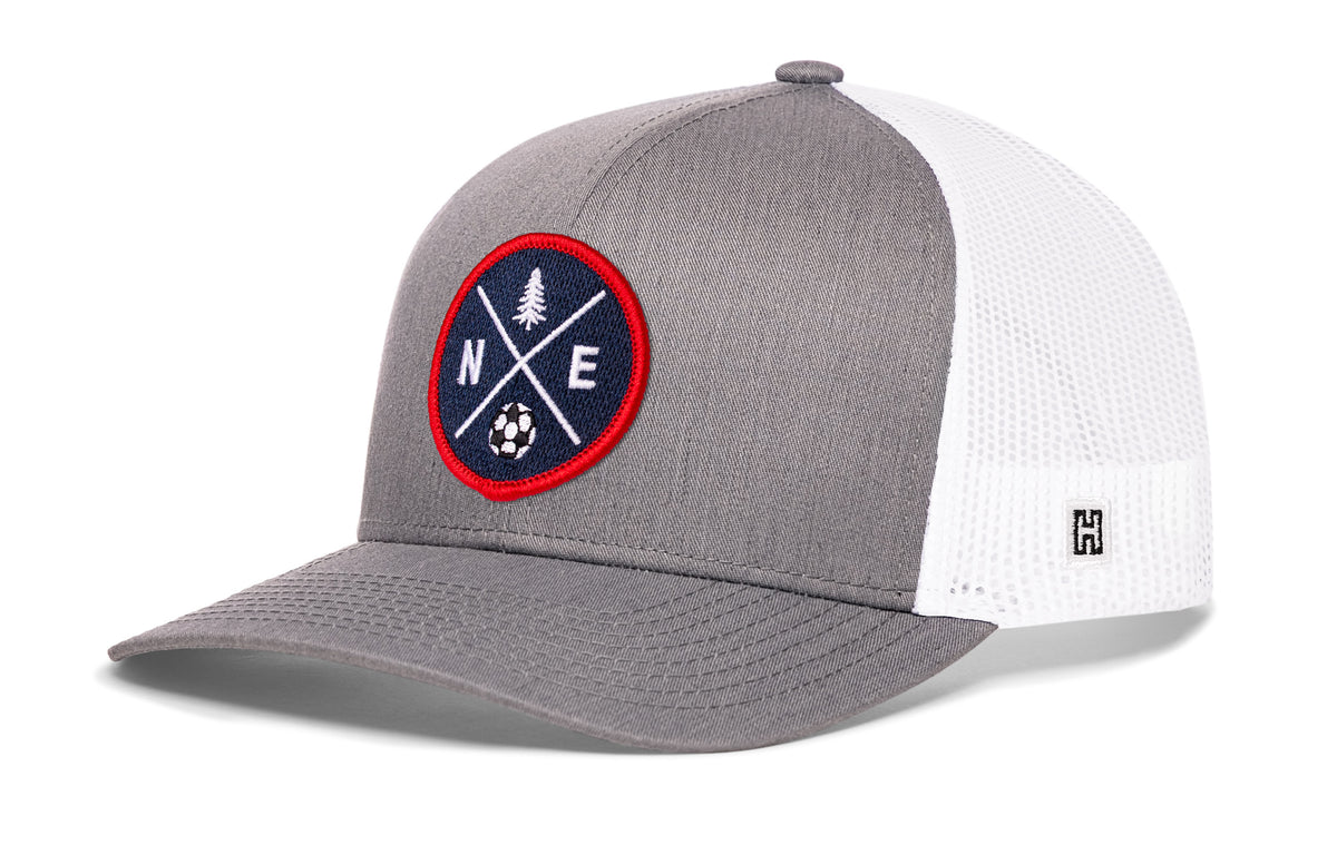 New England Soccer Trucker Hat, gray-white snapback showing Haka brandmark on left side of cap.