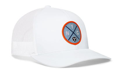 white trucker hat viewed from the right side, showcasing a bold sky blue and orange embroidered X patch prominently displayed on the front