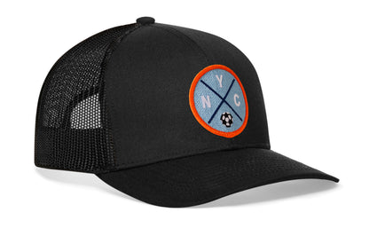 black trucker hat viewed from the right side, showcasing a bold sky blue and orange embroidered X patch prominently displayed on the front