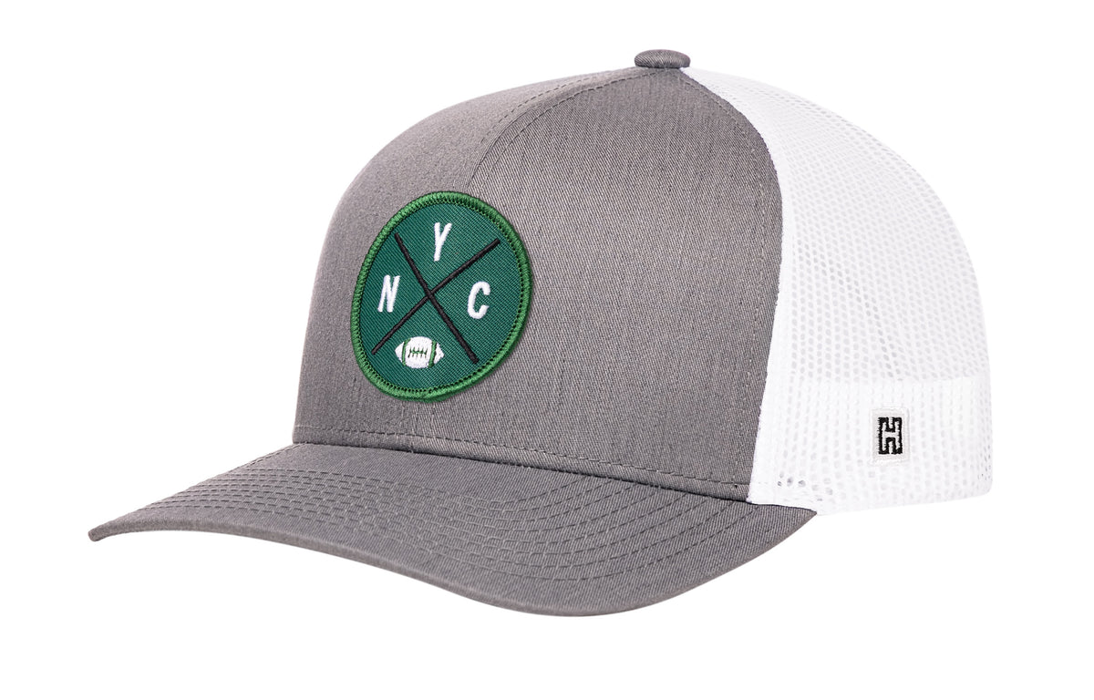 New York Football Trucker Hat, gray-white snapback showing Haka brandmark on left side of cap.