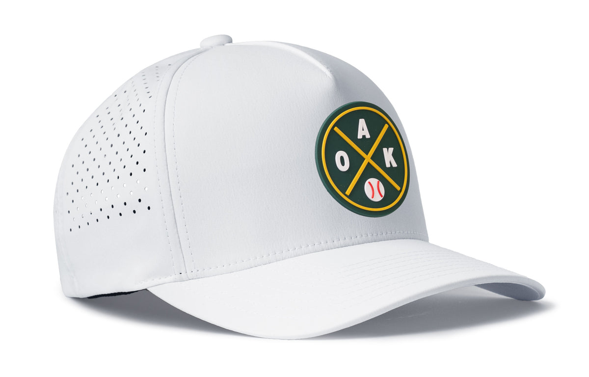 white performance 5-panel hat viewed from the right side, showcasing a bold green and gold pvc patch prominently displayed on the front