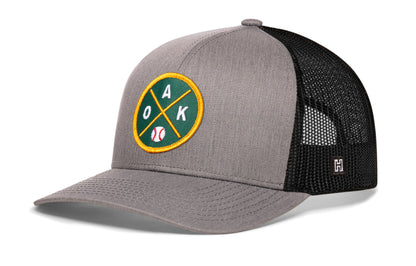 Oakland Baseball Trucker Hat, gray-black snapback showing Haka brandmark on left side of cap.