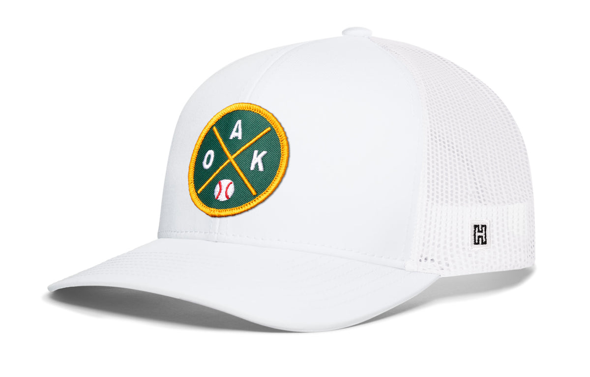 Oakland Baseball Trucker Hat, white snapback showing Haka brandmark on left side of cap.