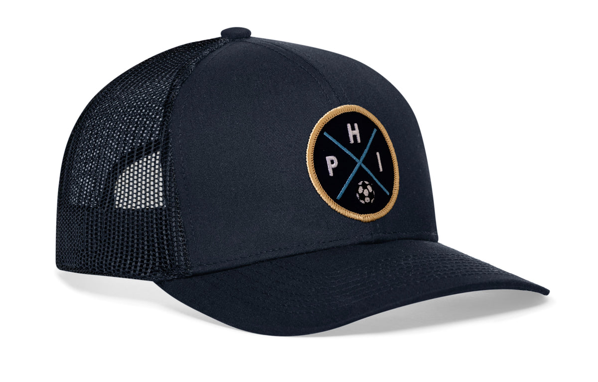 navy trucker hat viewed from the right side, showcasing a bold navy and gold embroidered X patch prominently displayed on the front