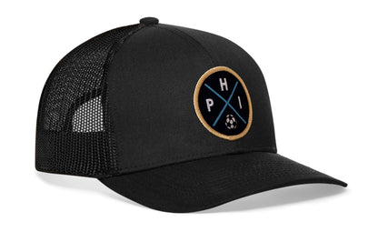 black trucker hat viewed from the right side, showcasing a bold navy and gold embroidered X patch prominently displayed on the front