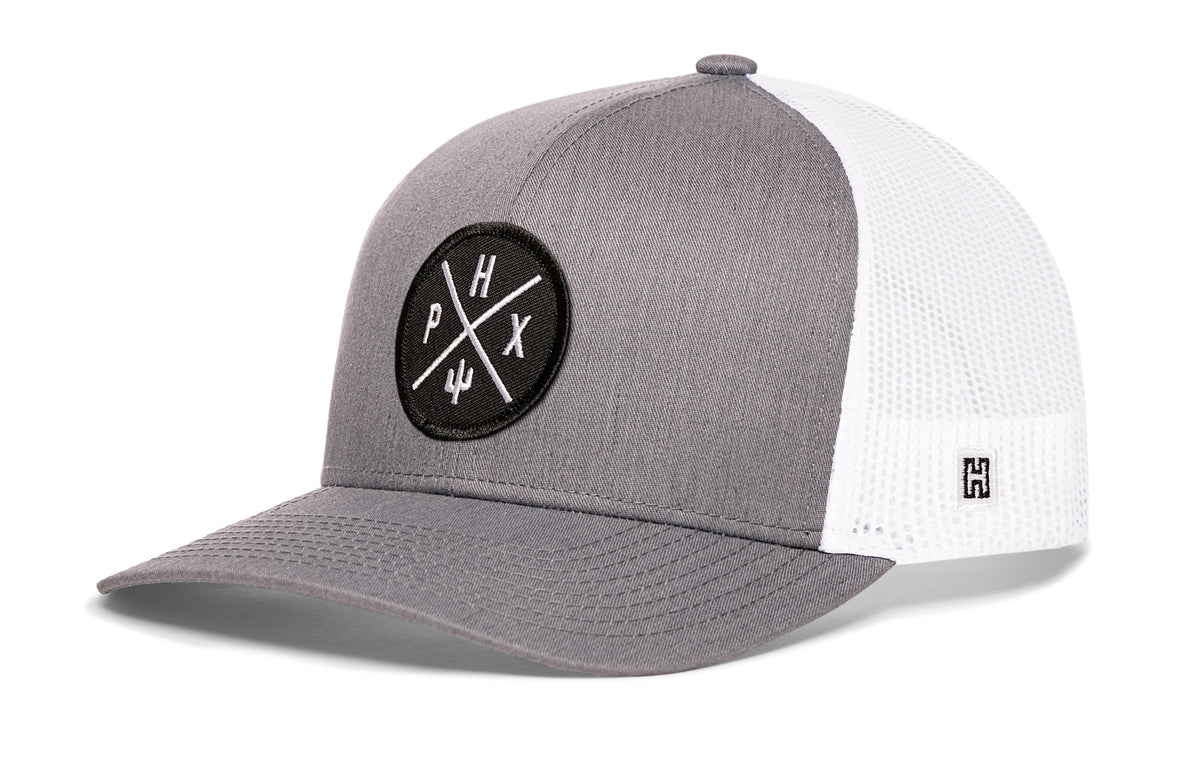 Phoenix Trucker Hat, gray-white snapback showing Haka brandmark on left side of cap.