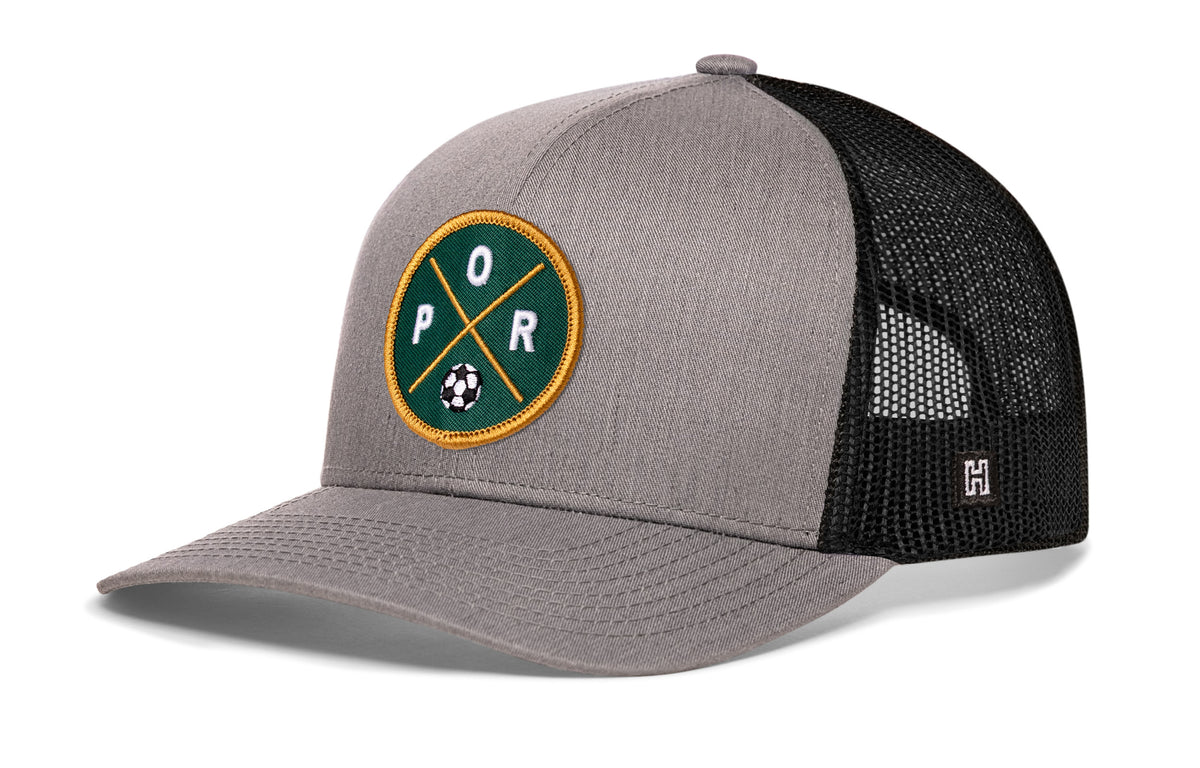Portland Soccer Trucker Hat, gray-black snapback showing Haka brandmark on left side of cap.