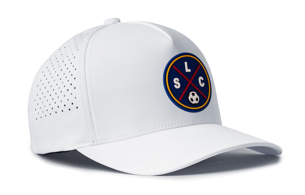 white performance 5-panel hat viewed from the right side, showcasing a bold deep red and blue pvc patch prominently displayed on the front