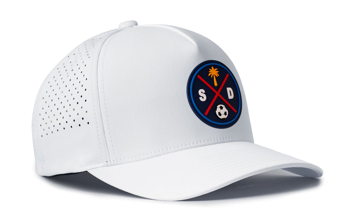 white performance 5-panel hat viewed from the right side, showcasing a bold navy and orange pvc patch prominently displayed on the front