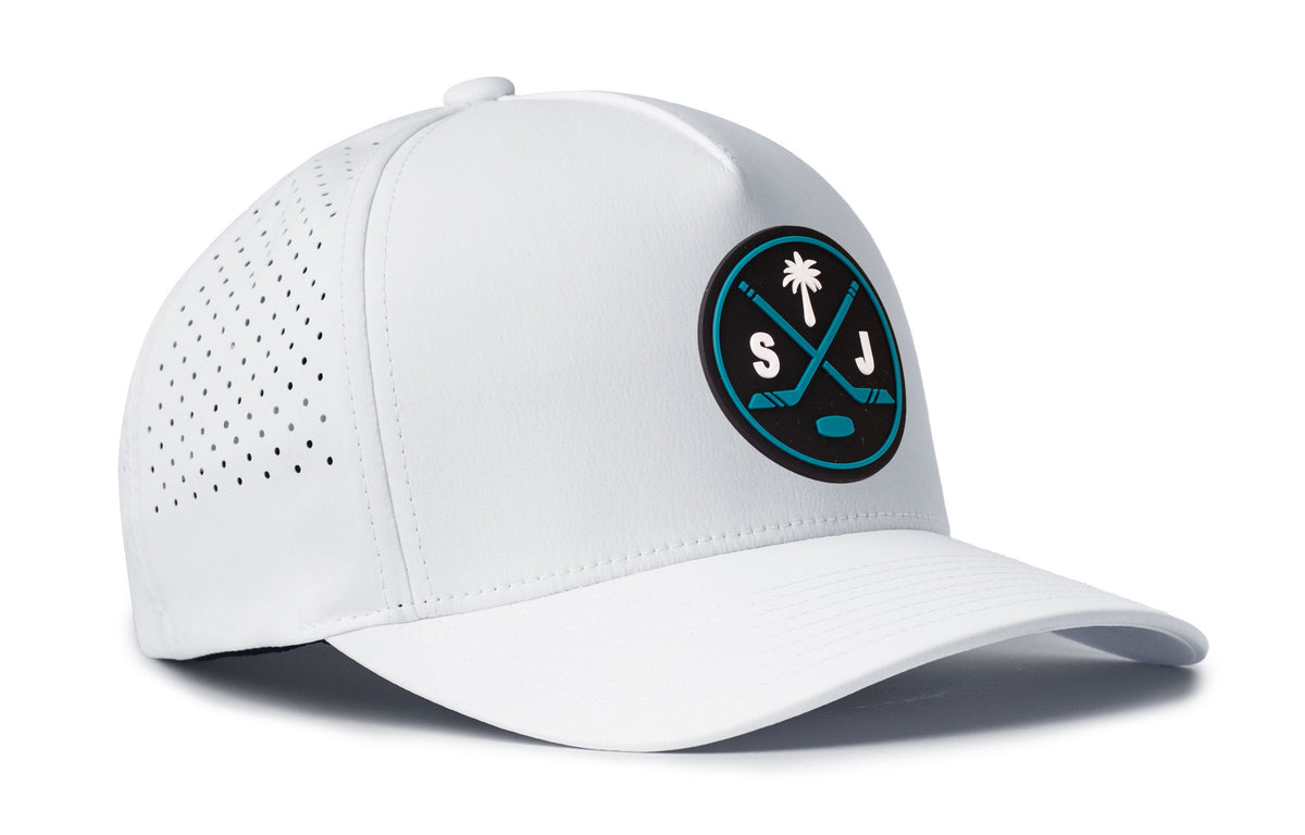 white performance 5-panel hat viewed from the right side, showcasing a bold black and teal pvc patch prominently displayed on the front