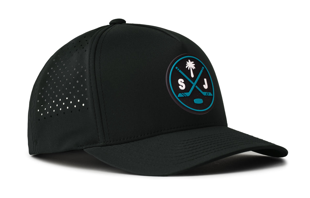 black performance 5-panel hat viewed from the right side, showcasing a bold black and teal pvc patch prominently displayed on the front