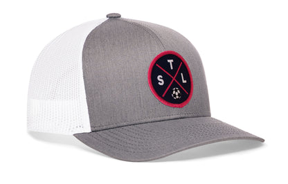 gray-white trucker hat viewed from the right side, showcasing a bold red and blue embroidered X patch prominently displayed on the front