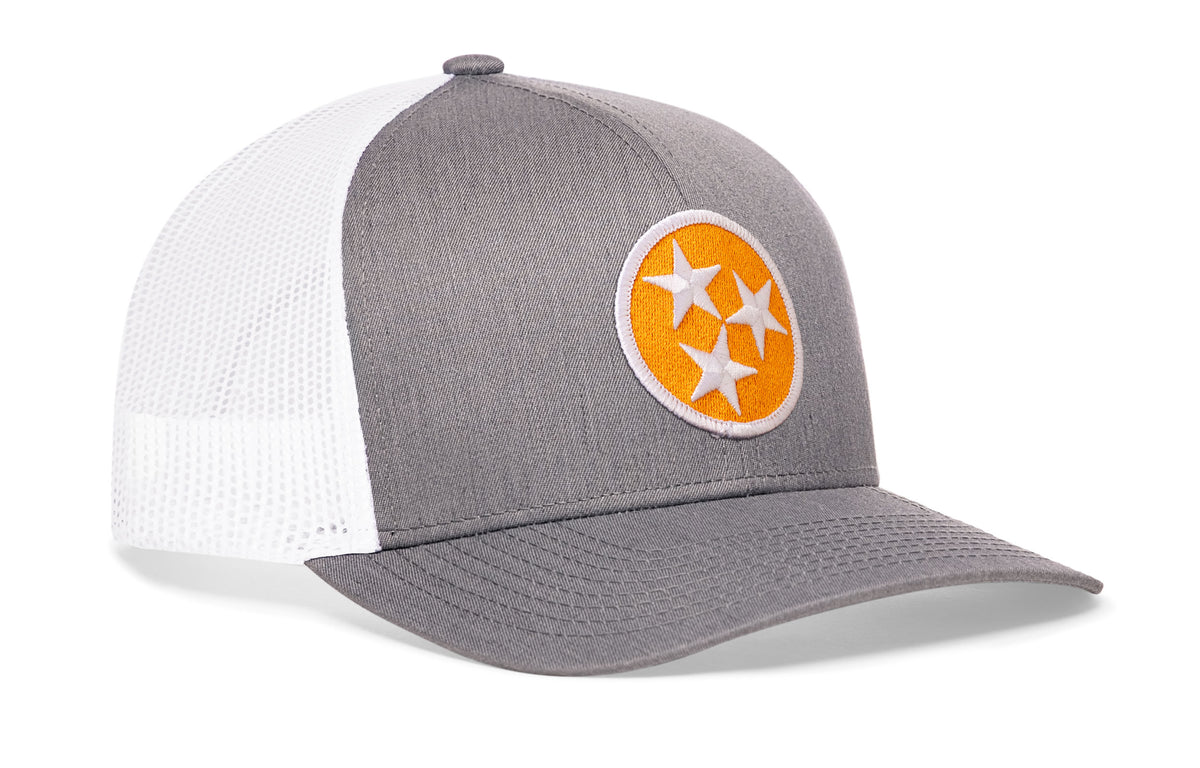 gray-white trucker hat viewed from the right side, showcasing a bold orange and white embroidered flag patch prominently displayed on the front